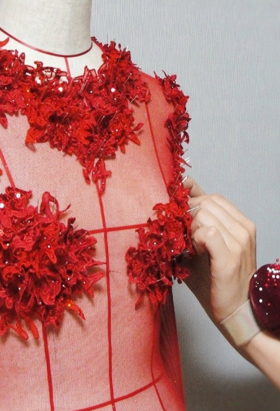 Bespoke couture designer draping a luxurious evening gown on a dress form, demonstrating the artisan craftsmanship of Keiko Tagai.